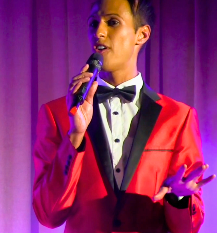 Jamezy in a red sequined suit hosting an event